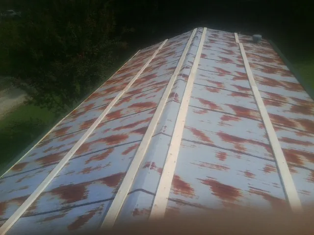 Rusted metal roof panels with new wood purlins before replacement — Storm Damage Roof Repair in Shepherd by Roofing Brothers