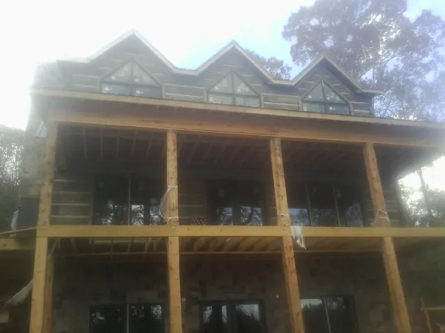 Dormers and porch framing on a large log home under construction — Roof Coating work by our crew in Shepherd